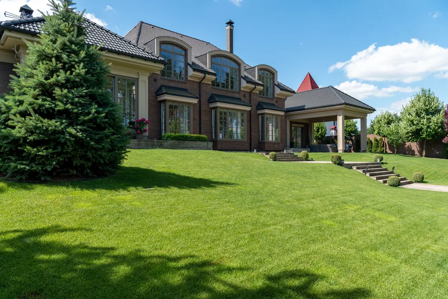 A large house behind a wide striped lawn